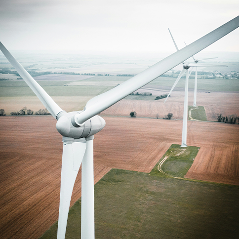 Wind turbines in a vast agricultural landscape.